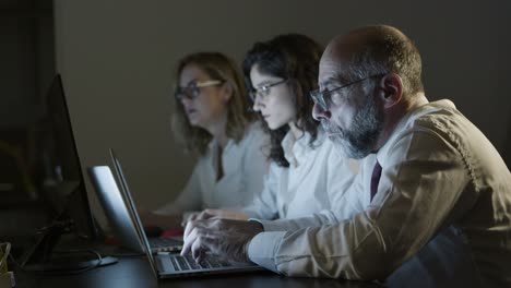 Gente-De-Negocios-Cansada-Con-Computadoras-Portátiles-En-Una-Oficina-Oscura